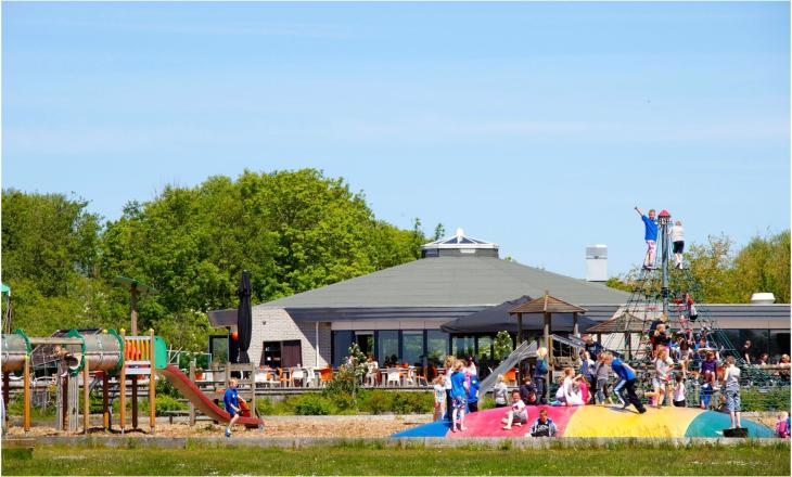Hoofdgebouw en speeltuin op Vakantiepark Lauwersoog